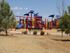 A children's playground with red, yellow, and blue equipment near a dog park. | Pet-friendly rental houses, Schriever SFB, Colorado Springs CO
