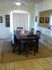 A dining room with a dark table and chairs and an open view of the living room. | Rental Houses near Holloman AFB, Alamogordo, NM