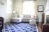 A brightly lit living room with light gray furniture and a deep blue rug. | Rental Houses near Los Angeles AFB