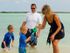 Man and Woman with 2 children playing at the beach | Hickam Communities | Hickam Communities