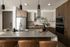 Modern kitchen with sleek appliances, pendant lighting, and an island countertop with stylish decor.