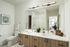 Contemporary bathroom with dual sinks, sleek lighting, and wooden cabinetry.