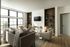 Bright and spacious living room featuring comfortable sofas, large windows, and stylish shelving units.