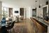 Stylish open-plan living room with modern furnishings and a kitchen island, featuring elegant lighting and cozy seating.
