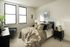 Bright and cozy bedroom with modern decor, featuring a plush bed, stylish throw pillows, and dual windows.