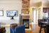 Inviting apartment living space featuring a cozy fireplace, modern TV setup, and stylish seating with warm wooden flooring.