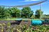 Charming outdoor space featuring green benches, lush greenery, and a playful tunnel, perfect for relaxation and recreation.