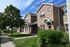 Charming townhouse with brick exterior and lush greenery, offering a cozy and inviting atmosphere.