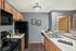 Modern kitchen with sleek black appliances, cozy wooden cabinetry, and elegant gray walls, perfect for culinary creativity.