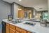 Charming kitchen view featuring a sleek countertop, dual sink, and stylish decor accents with a glimpse into the cozy living room.
