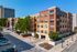 Contemporary apartment complex in urban setting featuring vibrant exterior, lush greenery, and ample parking.