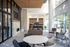 Elegant modern living space with a cozy seating area, large windows, and a sleek open kitchen with bar stools.