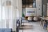 Elegant and modern communal space with cozy seating, stylish pendant lights, and contemporary art on the wall.