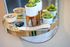 Elegant round mirror shelf with lush succulent plants, decorative stones, and a stylish keychain enhancing modern decor.