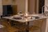 Elegant dining area featuring modern gold wire chairs, a sleek countertop, and ambient candlelight for a cozy atmosphere.