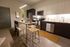 Modern kitchen with sleek cabinetry, stainless steel appliances, and cozy island seating in an inviting open-plan layout.
