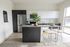 Modern kitchen with sleek dark cabinetry, stainless steel appliances, and elegant open shelving featuring a stylish island and lush greenery centerpiece.