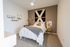 Inviting bedroom with stylish decor, featuring a cozy bed adorned with patterned throw and modern wall art.