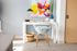 Chic home office corner with a modern white desk, stylish geometric chair, and vibrant abstract artwork, creating a bright and inspiring workspace.