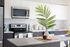 Modern kitchen with sleek stainless steel appliances, elegant white cabinetry, and a stylish island centerpiece featuring a decorative vase with greenery.