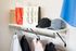 Chic and organized closet space featuring stylish hats, shopping bags, and a minimalist clothing rack with modern apparel.