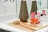 Chic bathroom vanity displaying premium skincare products, a stylish brown vase, and a luxurious body brush on a modern countertop.
