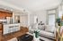 Chic apartment living area with modern kitchen, cozy seating, and elegant decor, featuring lush plants and natural light.