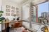 Chic home office with a stunning city view, featuring a stylish wooden desk, contemporary chair, and elegant wall art.