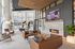 Elegant and inviting apartment lounge with modern furniture, cozy fireplace, and floor-to-ceiling windows offering natural light and vibrant decor.