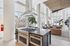 Luxurious open-concept apartment with modern kitchen, sleek island, and bright living area with floor-to-ceiling windows.