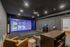 Modern entertainment room featuring a sleek gaming projector setup with cozy seating and a stylish wooden table.