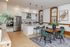 Modern open-plan kitchen and dining area with sleek stainless steel appliances, elegant island, and stylish wood accents. Inviting space for entertaining with natural light and chic decor.