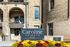 Charming Caroline Heights Apartments with rustic brick facade, elegant arches, and vibrant flower display.