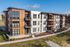 Contemporary apartment complex showcasing modern architectural design with large windows and balconies, surrounded by landscaped greenery.