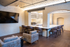 Chic loft-style living space featuring exposed brick, cozy seating, and a sleek bar area with modern stools.