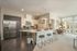 Modern kitchen and living area with sleek appliances, elegant island seating, and abundant natural light.