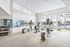 Modern apartment gym with natural light, equipped with treadmills, ellipticals, and free weights, perfect for fitness enthusiasts.