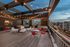 Chic rooftop terrace with cozy seating and city views, adorned with warm string lights and modern decor.