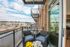 Charming balcony view with cozy seating overlooking a scenic riverside and modern urban skyline, perfect for relaxation.