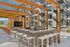 Modern outdoor lounge area with sleek bar seating and TV, framed by stylish wooden pergola, offering a perfect entertainment spot in a contemporary apartment complex.