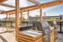 Modern rooftop deck with sleek barbecues, bright yellow chairs, and stunning city views, perfect for entertaining and relaxation.
