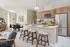 Contemporary open-concept kitchen with sleek wooden cabinetry, stainless steel appliances, and a chic dining area, perfect for stylish living and entertaining.