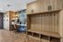 Modern workspace featuring elegant wooden cabinetry, sleek desk, and cozy chair set against a decorative accent wall.