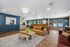Elegant open-plan living area with a stylish leather sofa and contemporary decor, featuring a cozy seating area, chic lighting, and a beautifully crafted wooden accent wall.