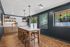 Contemporary kitchen featuring sleek wood cabinetry, warm parquet flooring, and a stylish island with modern lighting, perfect for entertaining.