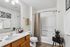 Modern bathroom featuring elegant lighting, smooth countertop with sink, stylish shower, and chic decor accents.