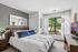 Bright and airy bedroom featuring a cozy bed, chic decor, and a large window with a scenic view, offering a perfect blend of comfort and style.