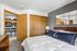 Cozy bedroom with elegant decor leading to a modern kitchen with bar seating.