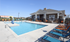 Inviting outdoor pool area with colorful lounge chairs and charming clubhouse in the background, perfect for relaxation and social gatherings.