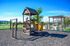 Charming outdoor playground with a wooden playset, slide, and swings, perfect for family fun in a serene community setting.